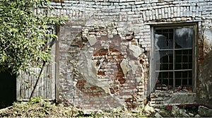 The facade of an old dilapidated house is cracked brickwork