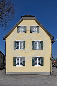Facade of an old generic house with wooden window shutter