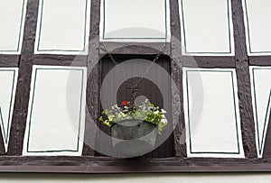Facade of an old half-timbered house with a vase with flowers, Germany