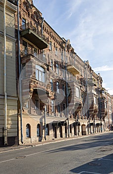 The facade of an old house in St. Petersburg. Balconies, loggias, gutters. Road. photo