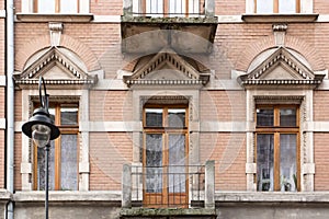 The facade of the old house with the balcony and street lamp