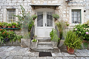 The facade of the old house is decorated with various plants and flowers