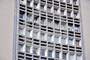 Facade of an old industrial office building with a predominance of old cement and old structural elements.