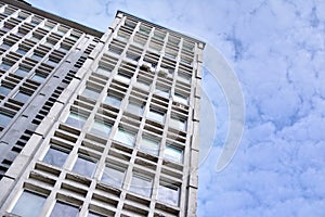 Facade of an old industrial office building with a predominance of old cement and old structural elements.