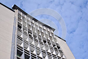 Facade of an old industrial office building with a predominance of old cement and old structural elements.