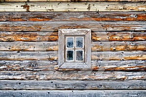 Facade of an old log house with a small window