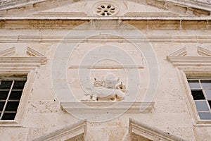 Facade of an old marble building with stucco moldings, cornices, platbands around the windows