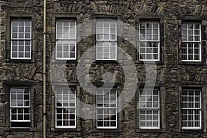 A facade of an old palace with 2 rows of windows in Edinburgh old town