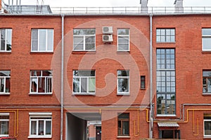 The facade of the old red brick building that was built 100 years ago against the backdrop of the White Sky. Ancient