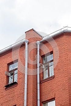 The facade of the old red brick building that was built 100 years ago against the backdrop of the White Sky. Ancient