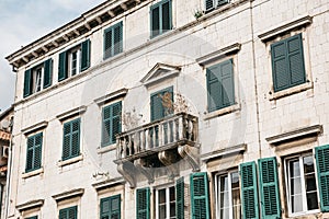 The facade of an ordinary old building with windows and a balcony in Montenegro.