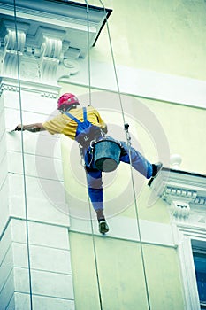 Facade painter on abseil ropes