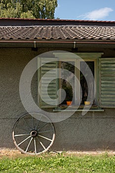 Facade of picturesque garden shed with carriage wheel