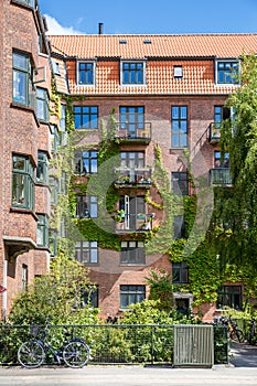 Facade of red brick Building with Balconies and Ivy, Copenhagen