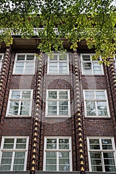 Facade of red brick Building with golden Ornaments and white Windows, Hamburg, Germany