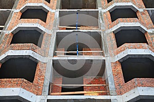 The facade of red brick modern residential building under construction