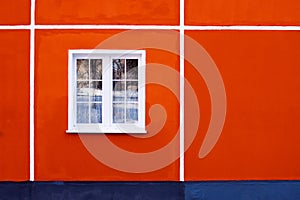 Facade of a residential building, a window with a white frame and red-brick walls, minimalism, linearity and clean design.