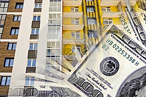 The facade of a residential high-rise house on a background of money .