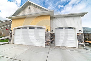 Facade of residential two car garage with gable roof and white panelled doors