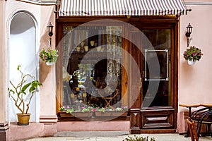 Facade of a retro cafe with a large window and a wooden door.