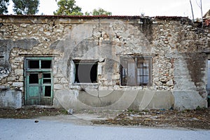 Facade of a ruined and dilapidated stone building.