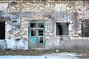 Facade of a ruined and dilapidated stone building.