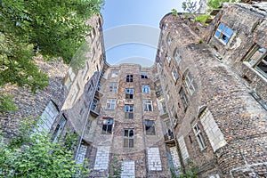 Facade of ruined old vintage red brick house with broken windows location: Kamienico, part of former Jewish ghetto, Walicow