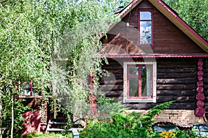 Facade of russian wooden log house in summer