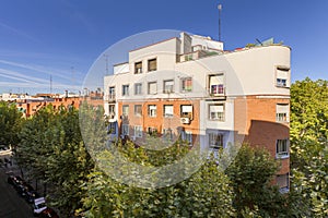 Facade of a singular building surrounded by leafy trees