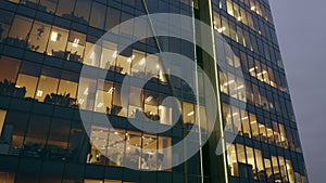 Facade of a skyscraper with office windows in the evening.