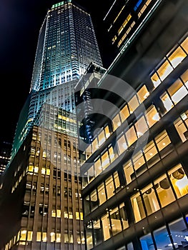 Facade of skyscrapers illuminated at night.