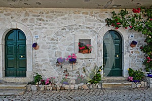 Facade of a stone house adorned with flowers in Scontrone Italy