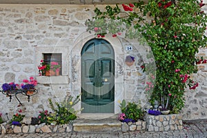 Facade of a stone house adorned with flowers in Scontrone Italy