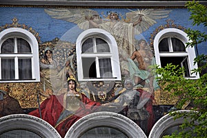 Facade, with three white windows, completely frescoed with oriental figures in a street in the historic center of Vienna.