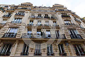 The facade of traditional French house with typical balconies and windows. Paris.