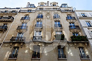 The facade of traditional French house with typical balconies and windows. Paris