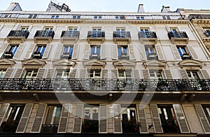 The facade of traditional French house with typical balconies and windows. Paris.