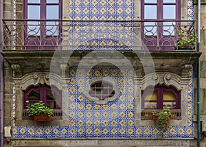 Facade of traditional house with ornate Portuguese azulejo tiles and flowers in the streets of old town Porto, Portugal
