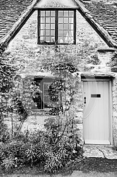 Facade of traditional small cottage home in Bibury village, Cotswolds, Egland, UK