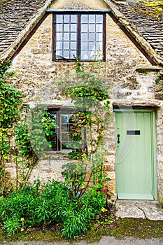 Facade of traditional small cottage home in Bibury village, Cotswolds, Egland, UK