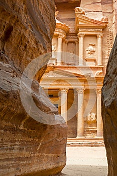 The facade of the Treasury Al Khazneh carved into the red rock, seen from the Siq, Petra, Jordan