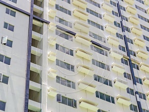 Facade of an typical affordable condominium. White painted concrete precast walls, ample windows and aircon ledges. photo