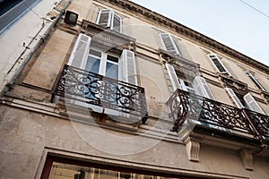 Facade of a typical old French residential building in Bordeaux, France, made of freestone, hosting flats,