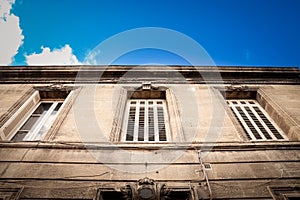 Facade of a typical old French residential building in Bordeaux, France, made of freestone, hosting flats, with a southwestern