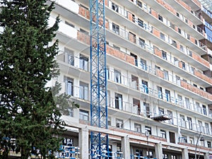 facade of an unfinished high-rise building. Construction crane near a panel house