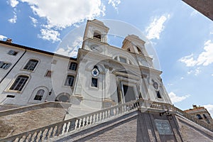 Facade view of The church of the Santissima TrinitÃ  dei Monti against blue sky above Spanish Steps, Rome, Italy