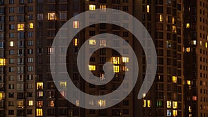 Facade view of living apartment building with glowing windows at night