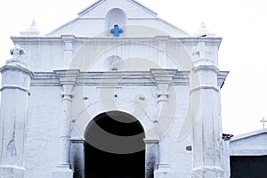 Facade of white Chapel of Calvary or Capilla del Calvario across the market square from the Church of Santo Tomas in