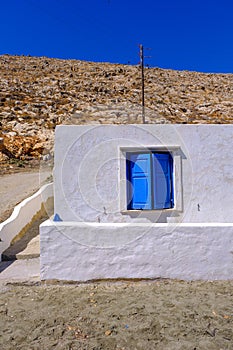 Facade of a whitewashed house with blue windows
