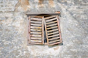 Facade with window of an old abandoned house with weathered wood